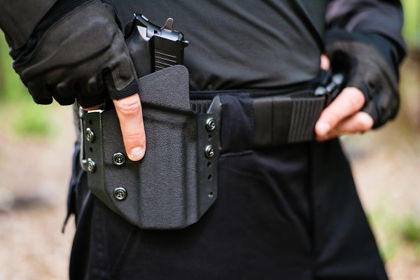 the guy puts the gun in the holster close-up