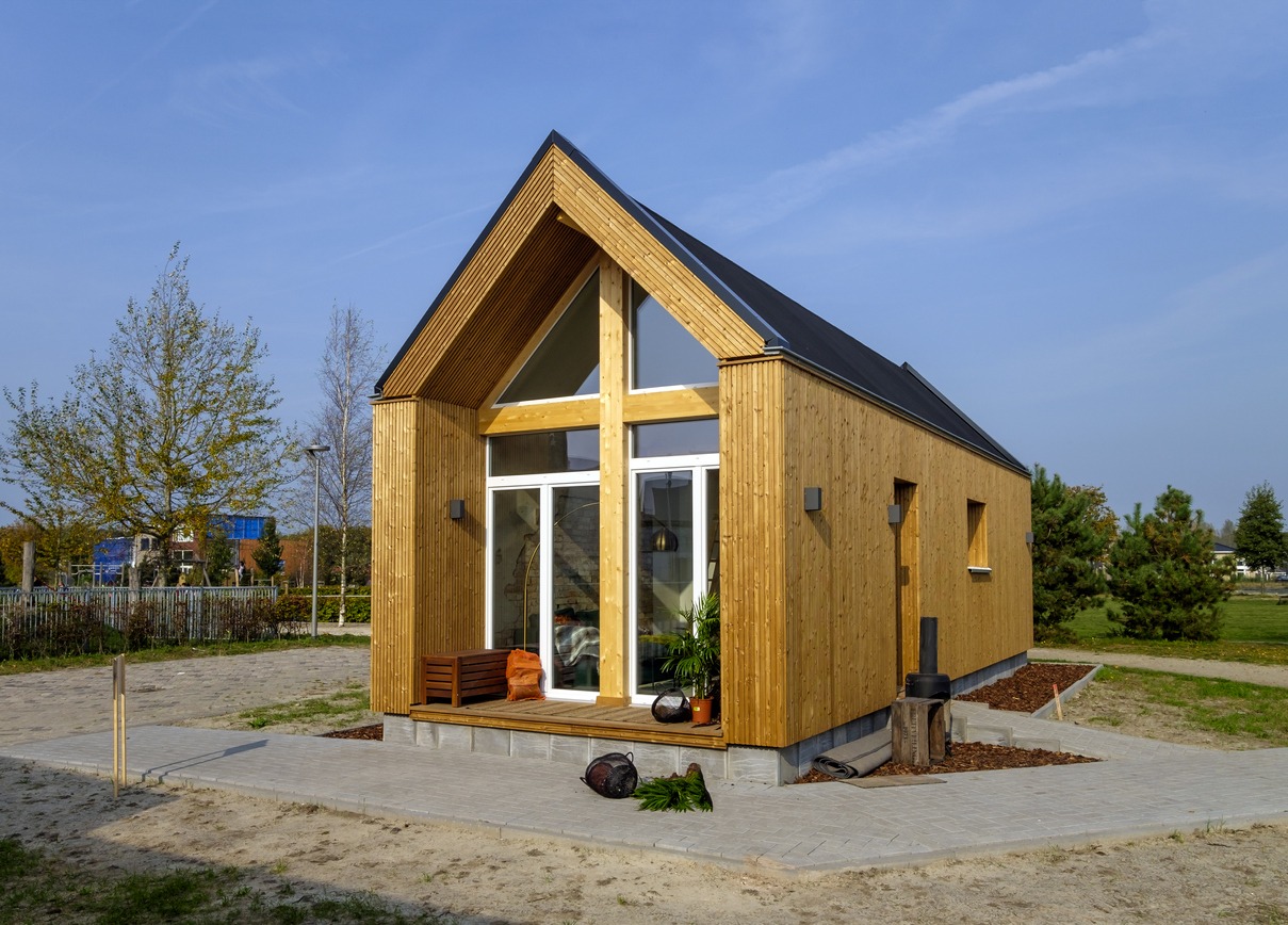 Outside view of a tiny house made of wood, against a blue sky