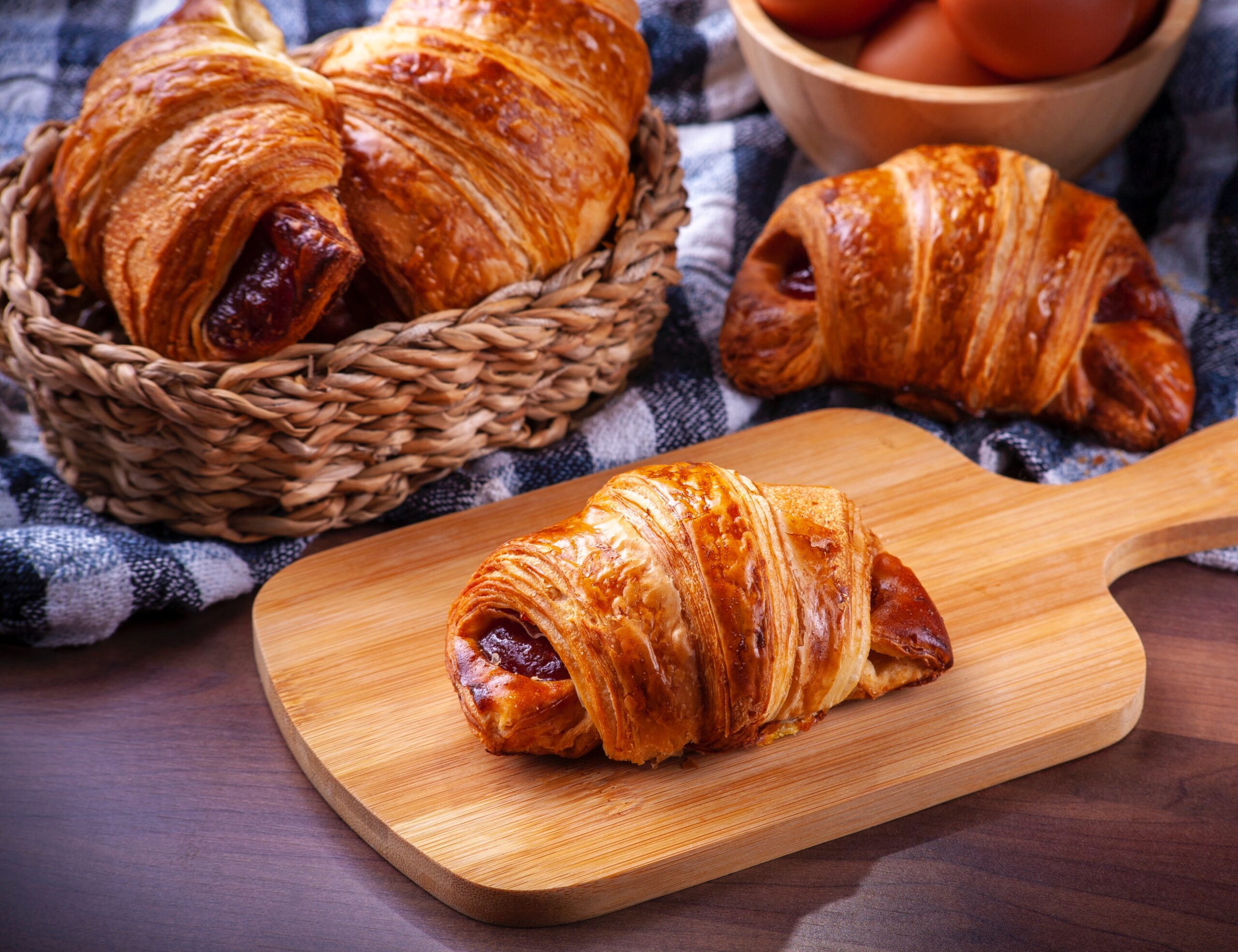 croissants-on-wicker-basket-and-wooden-board