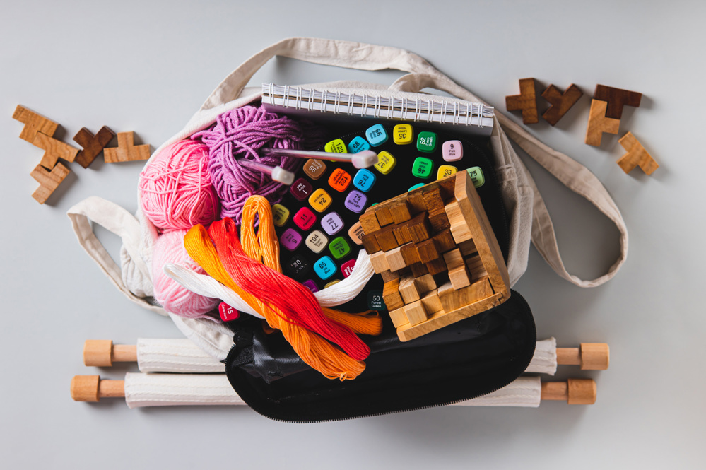 Close up of a tote bag with craft and leisure items on a table top view