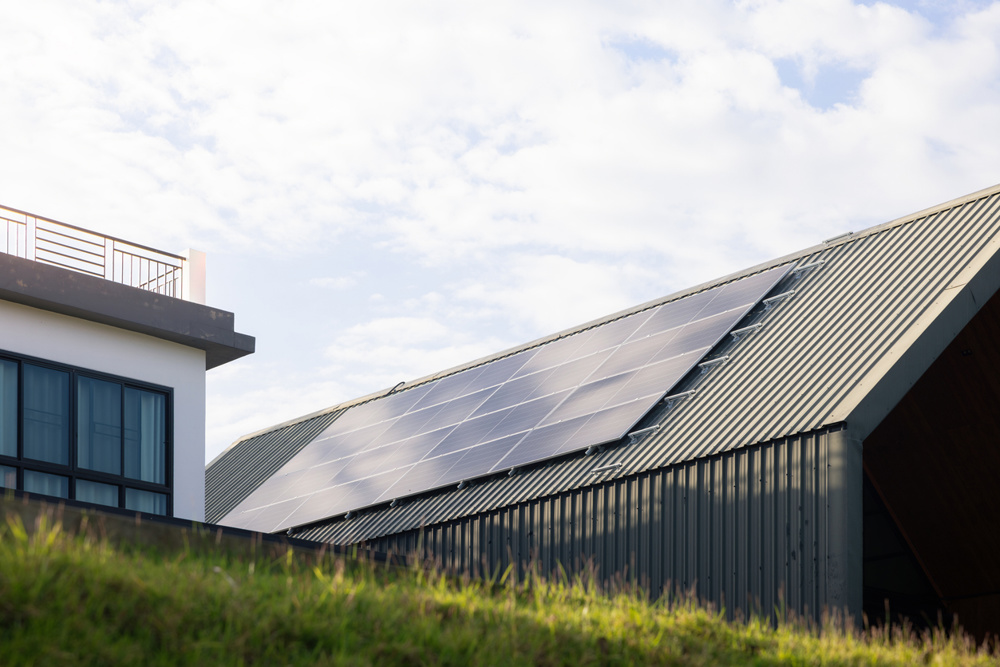 Sustainable Home for Saving Energy, modern house designed with solar panels installed on metal roof sheet, smart home technology for reducing electricity costs. Concept of smart saving