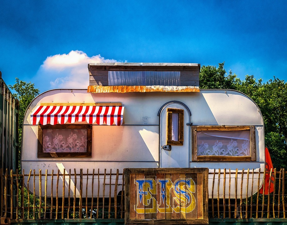 a simple trailer home parked by the trees