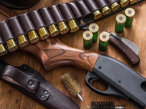 Pump action shotgun, 12 mm hunting cartridge and hunting knife.