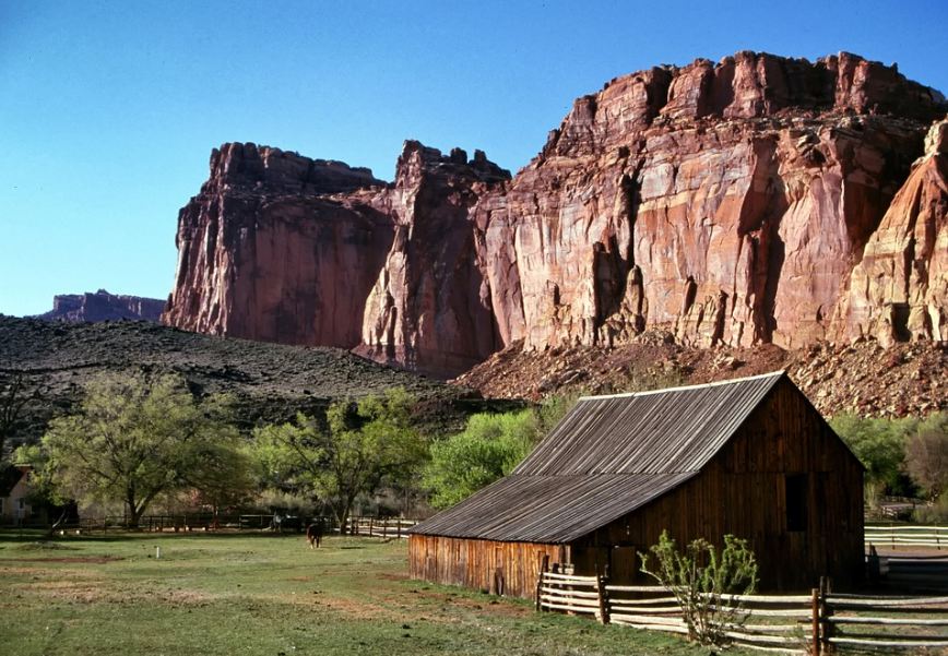a barn in Utah in front of red-colored mountains 