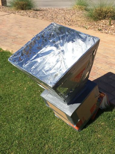 A Solar Oven made of cardboard, newspapers, and reflective tape