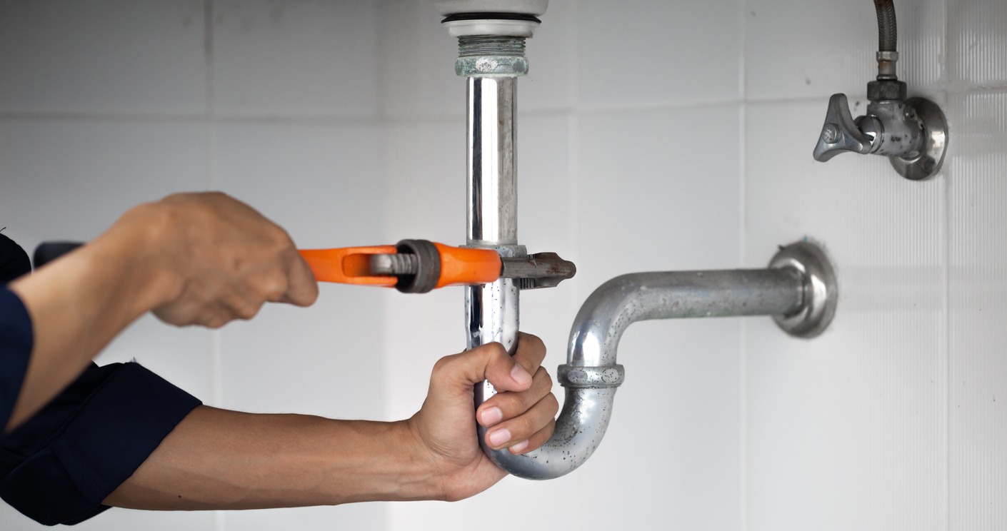 a plumber fixing leaks in a bathroom