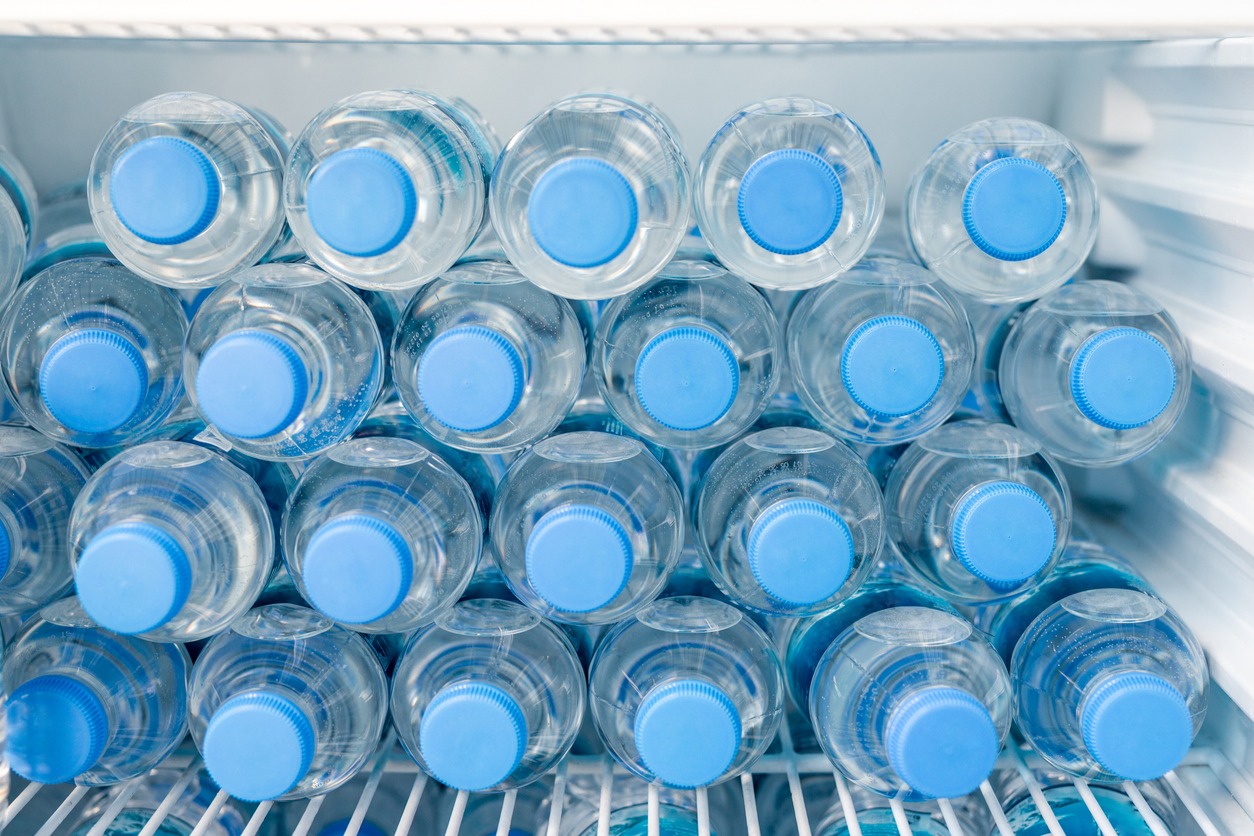 drinking water bottles stacked on a fridge